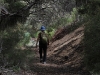 Nirbeeja passes through a tunnel of vegetation, Browns Beach to Gym Beach bushwalk